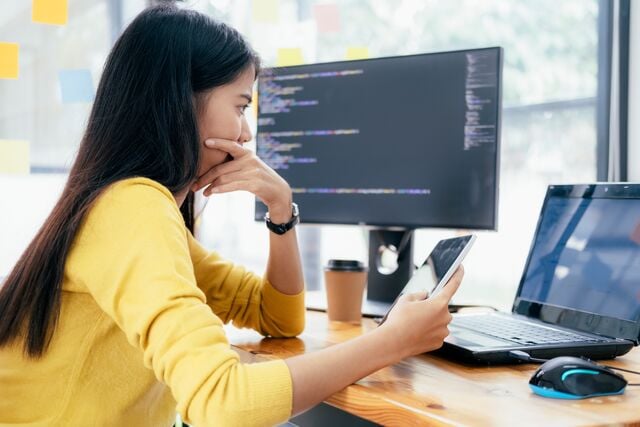 Cybersecurity analyst reviewing pen test results on dual screens